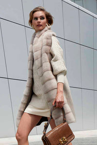 Pastel is the tone of the woman’s fur vest made of fox fur and worked horizontally. Short is the style of the fox fur vest collarless in amber color with suede inserts.