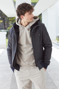Casual chic is the gritty shearling coat for men with hood. Soft nappa leather side dark blue. Welt pockets with press stud. Central closure with zip. Drawstring hood. Knitted inserts on the sleeves and on the cuffs