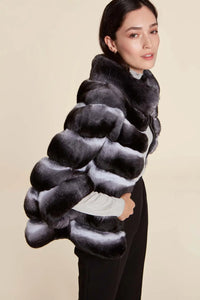 Short chinchilla fur jacket with oversized cut and central zip fastening. High neck and 3/4 sleeves. Hidden vertical pockets