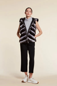 Short chinchilla vest with fur on the front and fur trimmed hood. The back part and the hood are made of padded and quilted cashmere