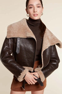 Oversized, cropped shearling jacket with wide collar and welt pockets. Aviator style and fastening with zip. Belt with buckle