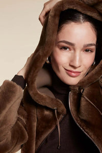 Reversible ladies sheepskin coat. Oversize fit with hood and patch pockets. Fastening with zip. Made of taupe grey shearling 