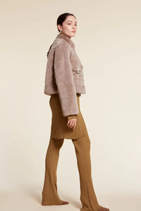 Short real  fur jacket with small collar and drawstring hem. Zip fastening. Chest pockets with a flap and buckle